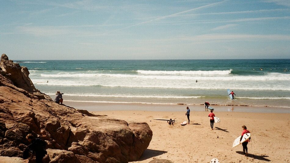 learner surfers going out to surf in Arrifana Portugal