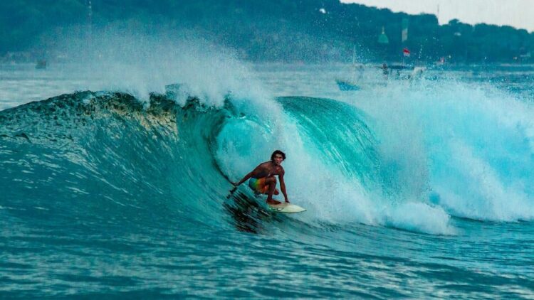 A surfer pulling into a barrel while on backhand in Indonesia Bali