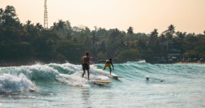 Hiriketiya surfers on a wave and easy surf beaches in Sri Lanka