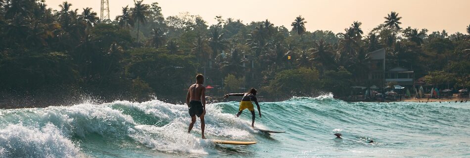 Hiriketiya surfers on a wave and easy surf beaches in Sri Lanka
