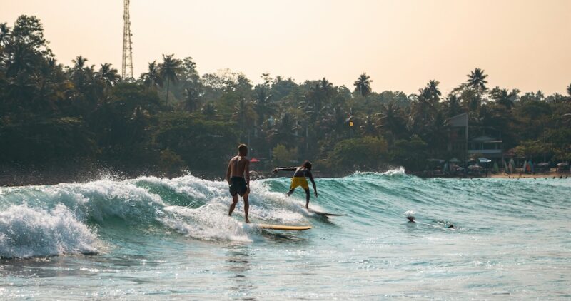 Hiriketiya surfers on a wave and easy surf beaches in Sri Lanka