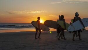 Surfers at sunset in Peniche who was also researched Peniche vs Ericeira beginner surf comparison