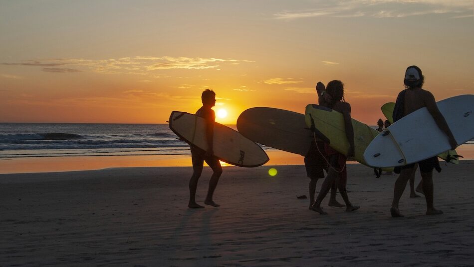 Surfers at sunset in Peniche who was also researched Peniche vs Ericeira beginner surf comparison