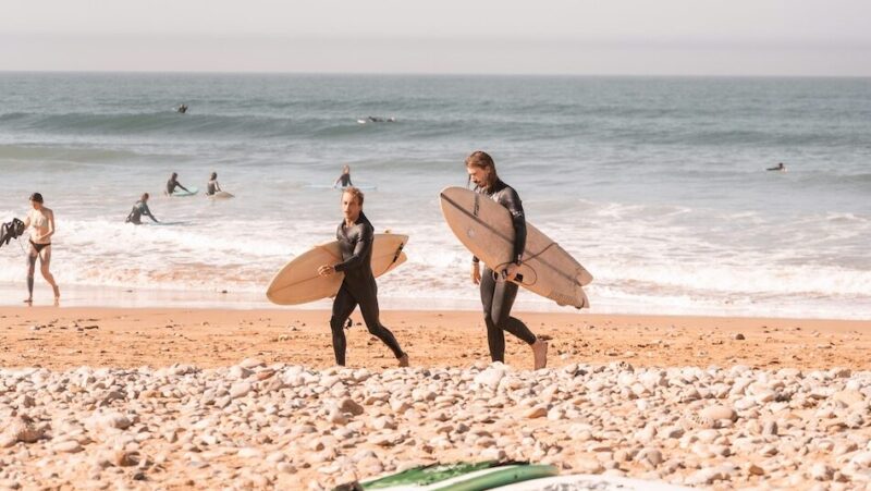 Surfers walking on the beach after surfing at Aourir Morocco