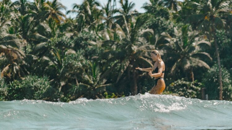 Water shot from behind of surfer riding a wave in Hiriketiya