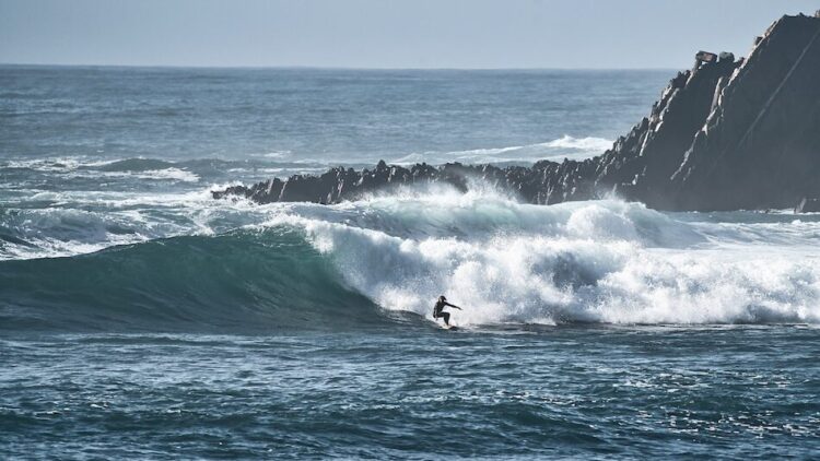 A surfer on a big wave in Arrifana Portugal