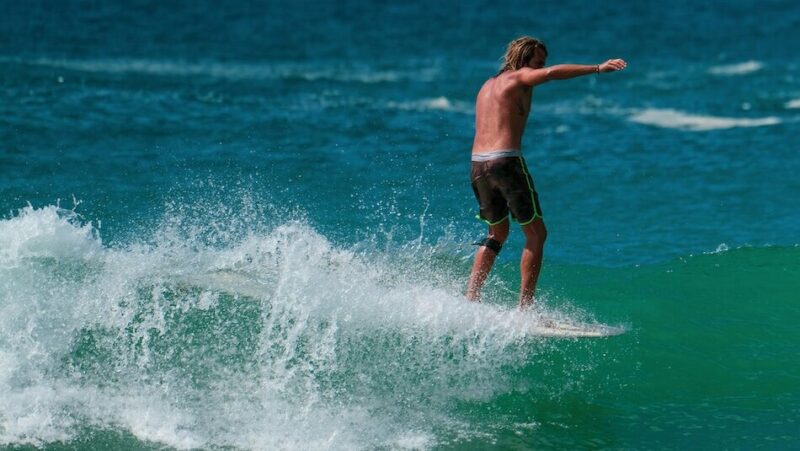 surfer riding a wave in weligam with blue water
