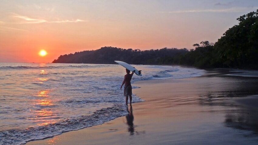 surfer with surfboard on his head watching the sunset in Santa Teresa Costa Rica