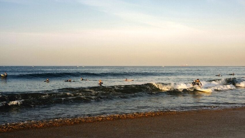 surfers catching a wave in Peniche