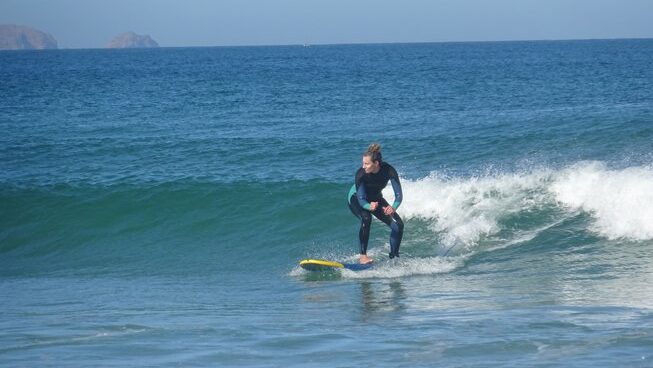 A learner surfer on a wave with Peniche Surf Lodge