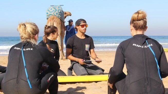 Surf instructor and camel with blue skies