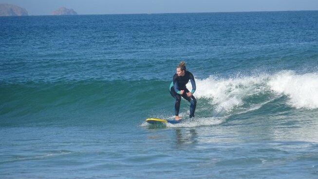 a learner surfer on a wave with Peniche Surf Lodge