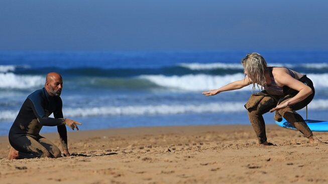 a learner surfer on the sand practicing