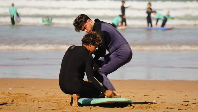 a surfer learning on the sand with The Surf Hotel Morocco