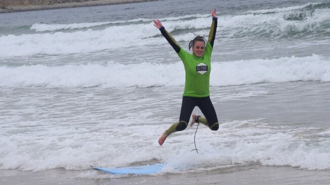 learner surfer jumping in the air happy