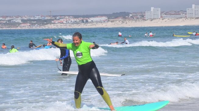 learner surfer on a wave standing up and happy