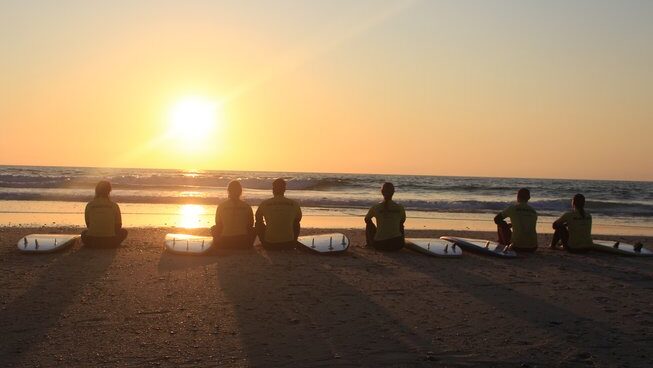 learner surfers enjoying the sunset