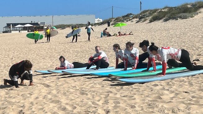 learner surfers practicing how to stand up with Peniche Surf Lodge
