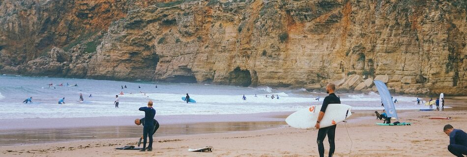 surfer on the beach thinking best week long surf camp in Portugal