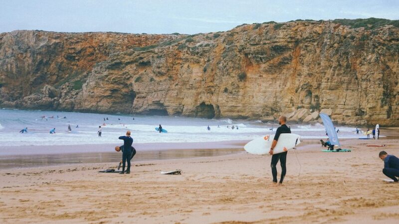 surfer on the beach thinking best week long surf camp in Portugal